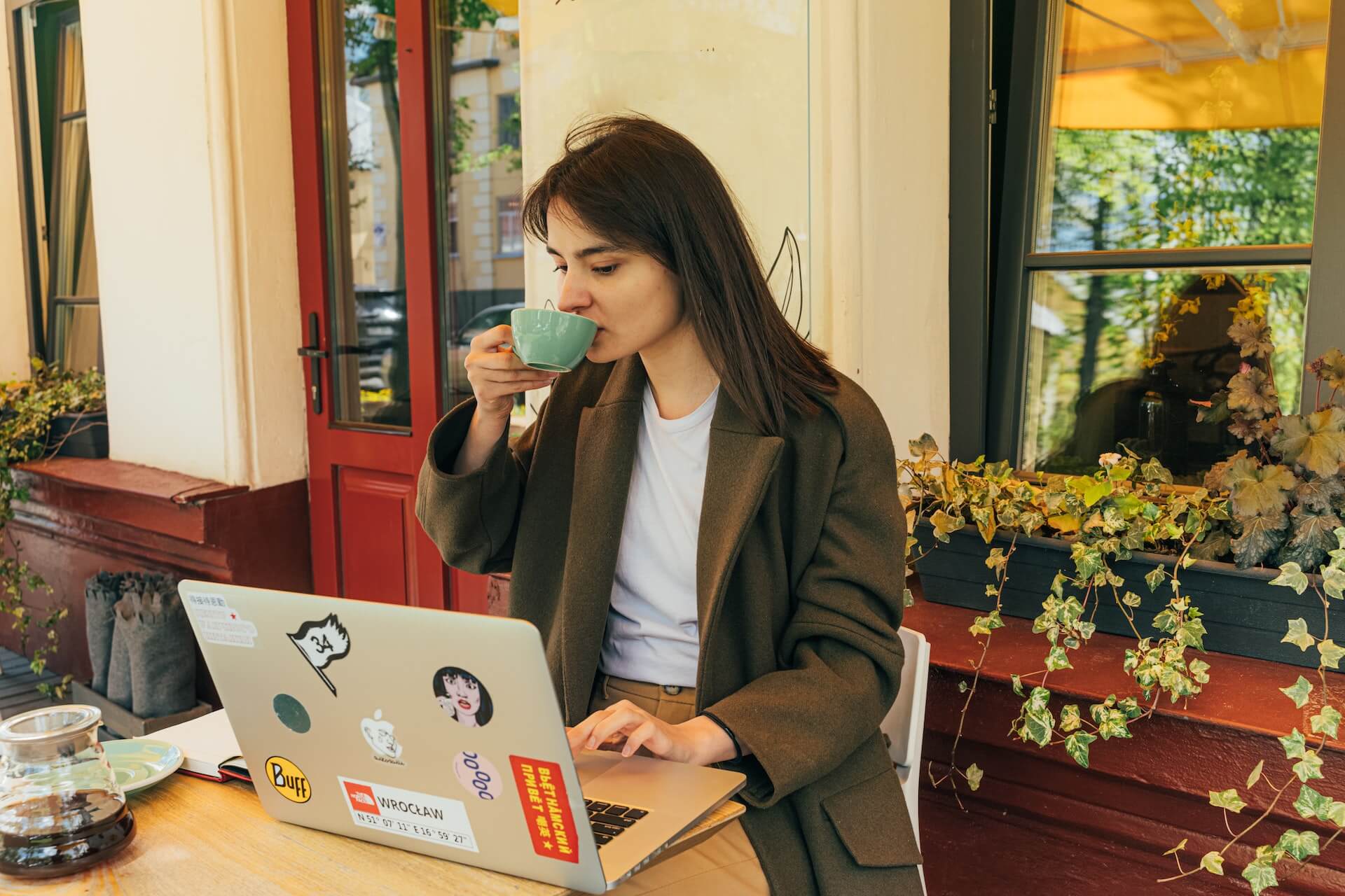 drinking coffee in front of laptop