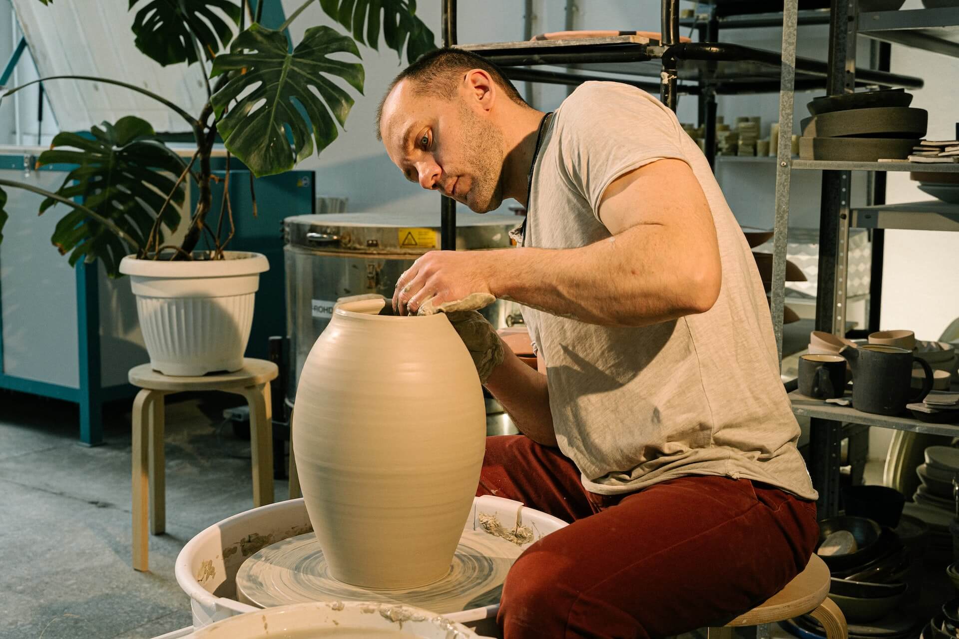 man forming a clay vase